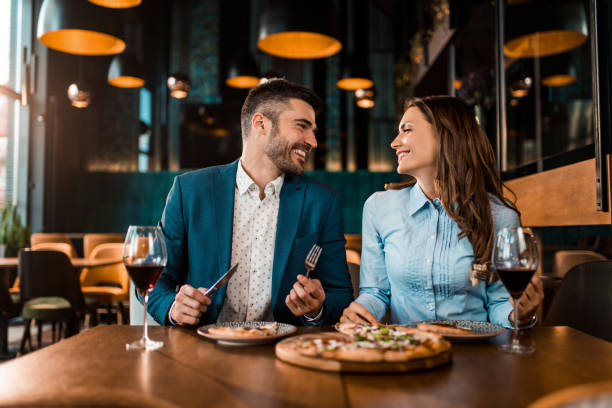 istock Playful couple eating pizza together in a restaurant. 1375934184