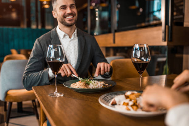 istock Happy man eating lunch with his girlfriend in a restaurant. 1375937480