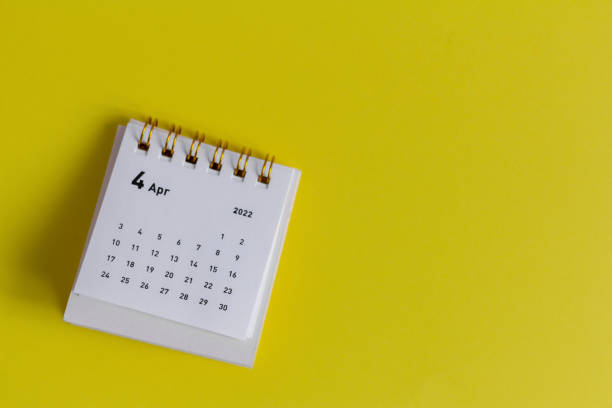 istock Desktop calendar for April 2022 for planning on a yellow background. 1375947371