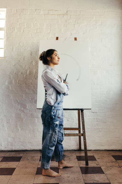 istock Female artist thinking of new creative ideas in her studio 1375959963