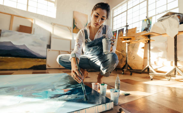 istock Female artist painting on a canvas in her studio 1375961047