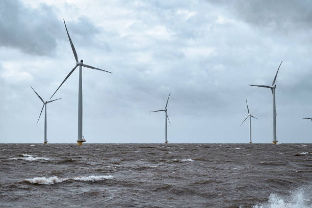 istock Wind turbines in an offshore wind park during a storm with big waves hitting the shore 1375964902