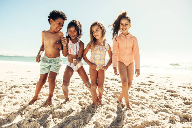 istock Active little kids playing together on beach sand 1375965435