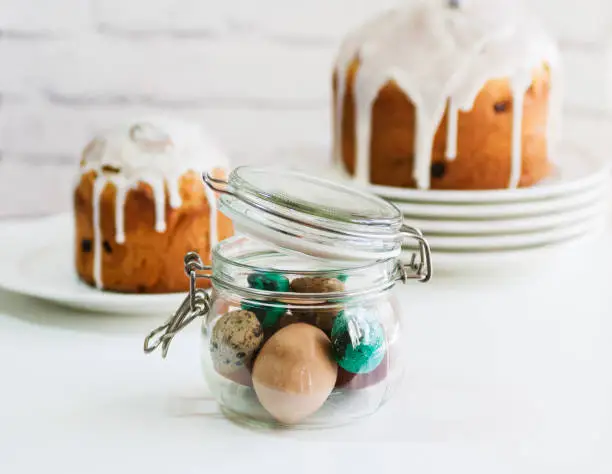 Photo of Easter cake and painted eggs in jar