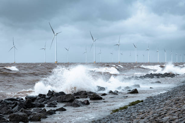 istock Wind turbines in an offshore wind park during a storm with big waves hitting the shore 1375973535