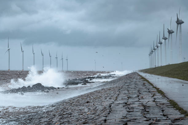 istock Wind turbines in an offshore wind park during a storm with big waves hitting the shore 1375977399