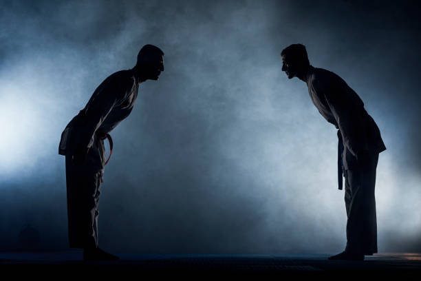 Karate kata training men isolated on dark background Brazilian jiu-jitsu BJJ training sparing on the tatami two fighters in guard position in training karate stock pictures, royalty-free photos & images