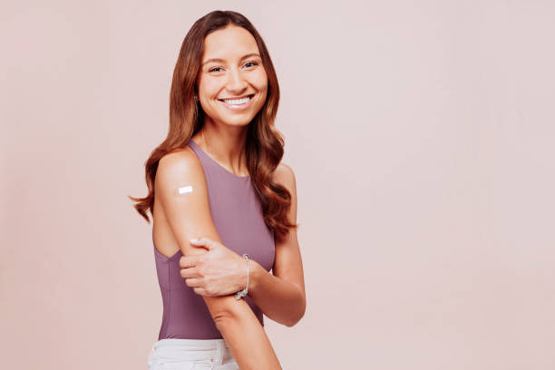 istock Vaccinated woman showing arm sitting at studio 1376029039