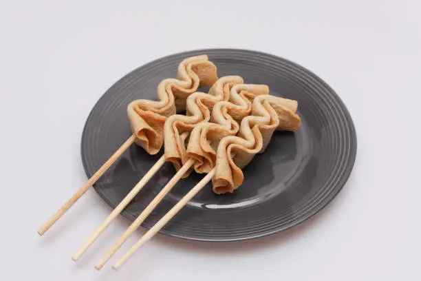 Fish cake skewers in a bowl on a white background