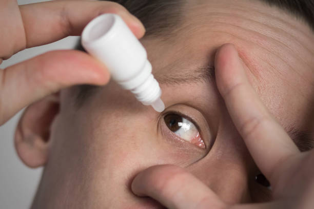 istock The man drops drops into his eyes. Close up 1376052821