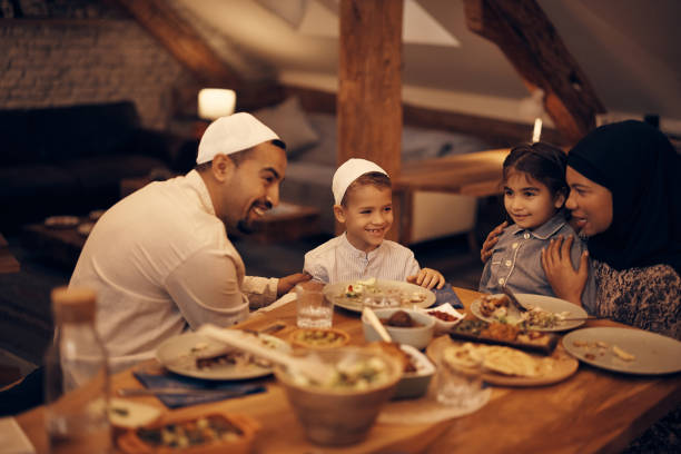 istock Happy Muslim family enjoying while talking during dinner at dining table. 1376083593