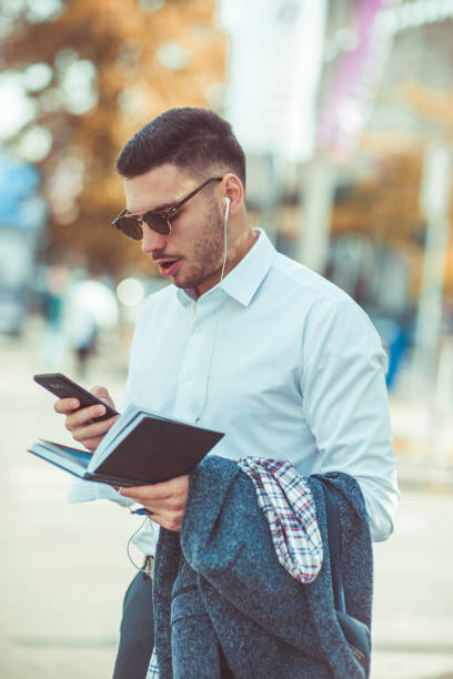 istock Eloquent businessman looking shocked at his phone and notebook 1376090417