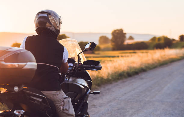 istock Motorcyclist on country road at sunset take a break from ride 1376090871
