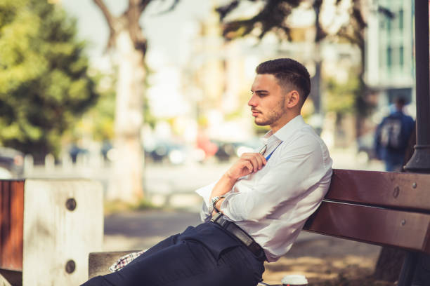istock Elegant businessman looking serious while sitting in the park 1376091070
