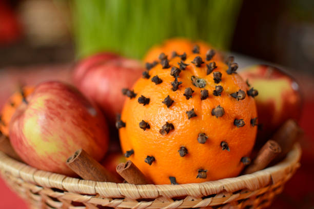 Close up of a child using finger to place cloves in orange
