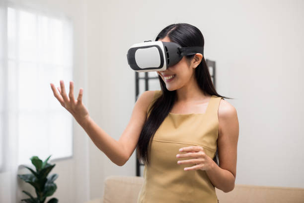 istock Young asian woman put on vr glasses into virtual simulated world. Future technology digital cyber universe. Person Enjoying an Experiences of Virtual World. 1376103581