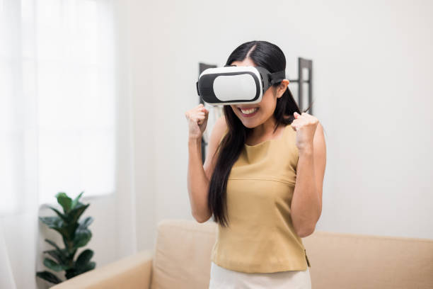 istock Young asian woman put on vr glasses into virtual simulated world. Future technology digital cyber universe. Person Enjoying an Experiences of Virtual World. 1376103891
