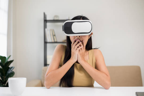 istock Young asian woman put on vr glasses into virtual simulated world. Future technology digital cyber universe. Person Enjoying an Experiences of Virtual World. 1376104033