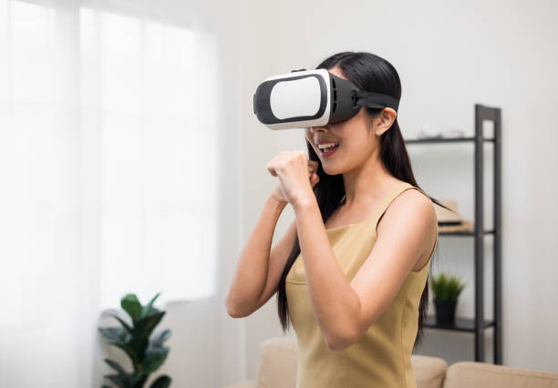 istock Young asian woman put on vr glasses into virtual simulated world. Future technology digital cyber universe. Person Enjoying an Experiences of Virtual World. 1376104055