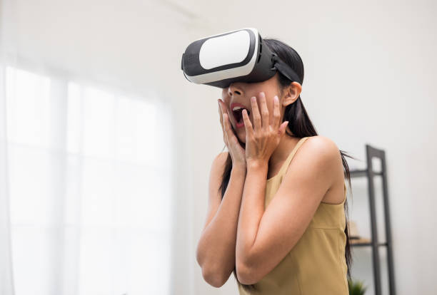istock Young asian woman put on vr glasses into virtual simulated world. Future technology digital cyber universe. Person Enjoying an Experiences of Virtual World. 1376104066