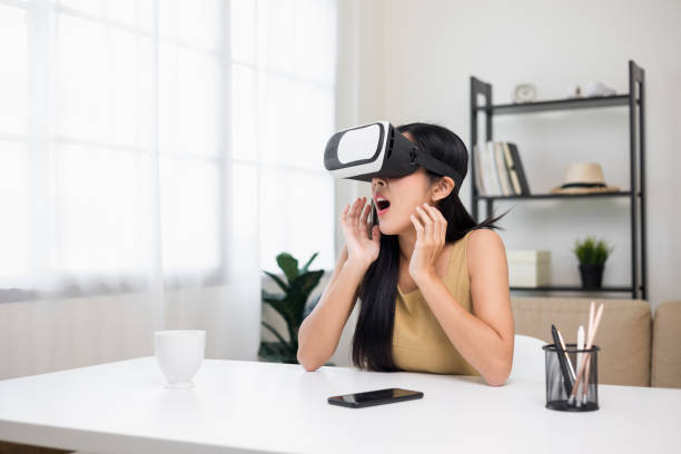 istock Young asian woman put on vr glasses into virtual simulated world. Future technology digital cyber universe. Person Enjoying an Experiences of Virtual World. 1376104094
