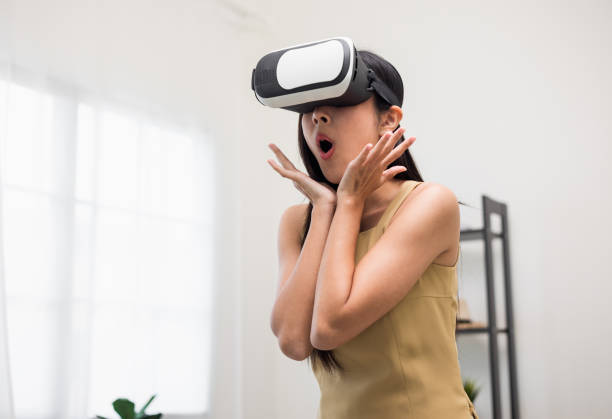 istock Young asian woman put on vr glasses into virtual simulated world. Future technology digital cyber universe. Person Enjoying an Experiences of Virtual World. 1376104116
