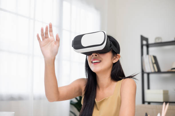Young asian woman put on vr glasses into virtual simulated world. Future technology digital cyber universe. Person Enjoying an Experiences of Virtual World.