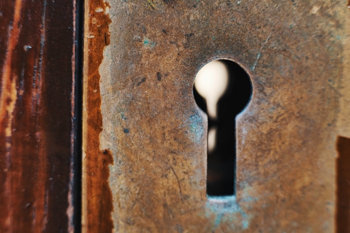 Open lock on a green rustic barn door.