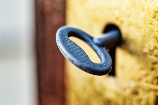 Metal key in old door keyhole