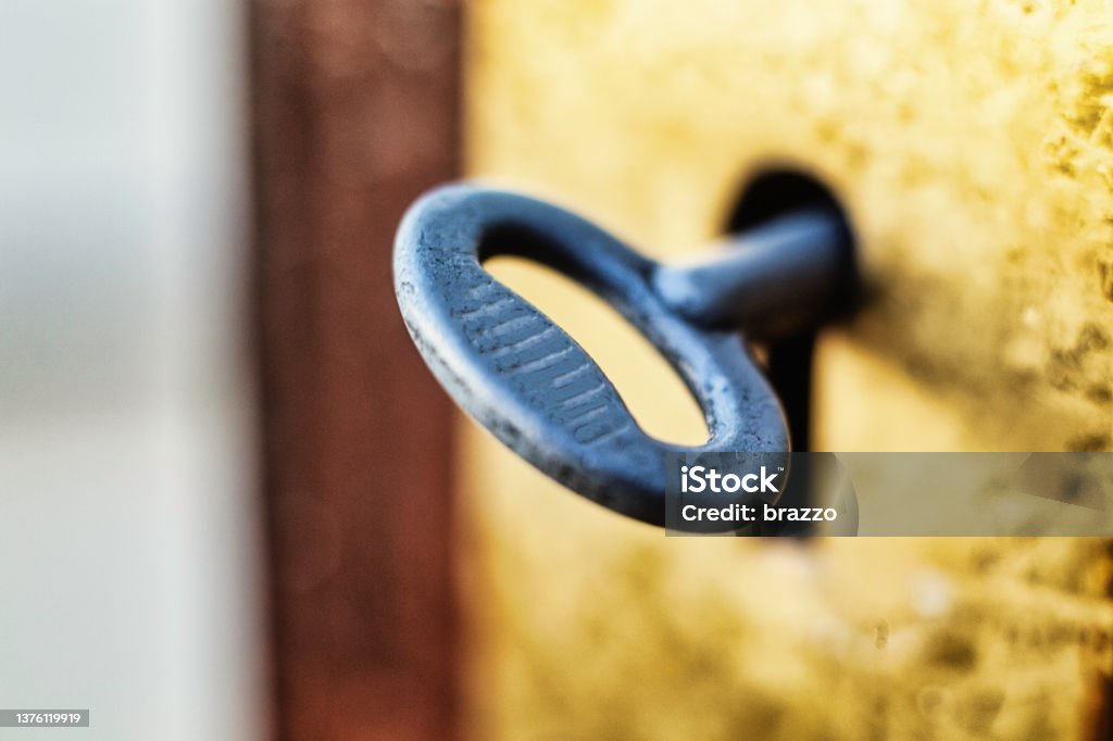 Key in keyhole Metal key in old door keyhole Key Stock Photo