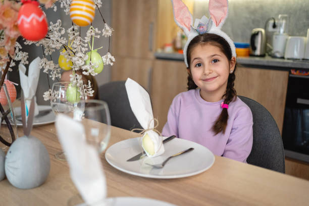 Portrait of cute Caucasian girl, wearing costume rabbit ear, during easter lunch