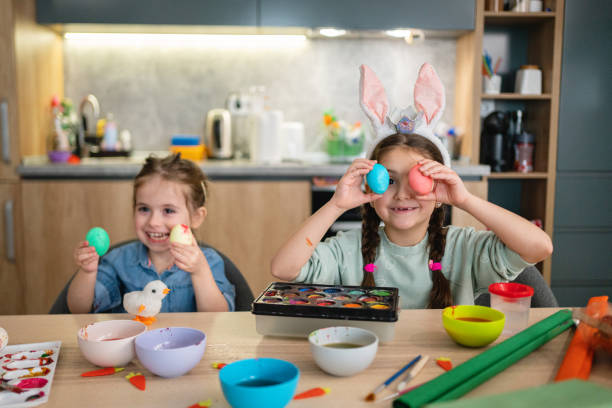 istock Playful Caucasian sisters, putting the painted easter eggs in front of their eyes 1376126057