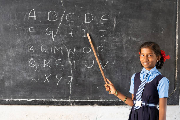istock girl kid from blackboard at public school teaching alphabets to classmates by looking at camera - concept of intelligence, knowledgeable, development and education 1376136248