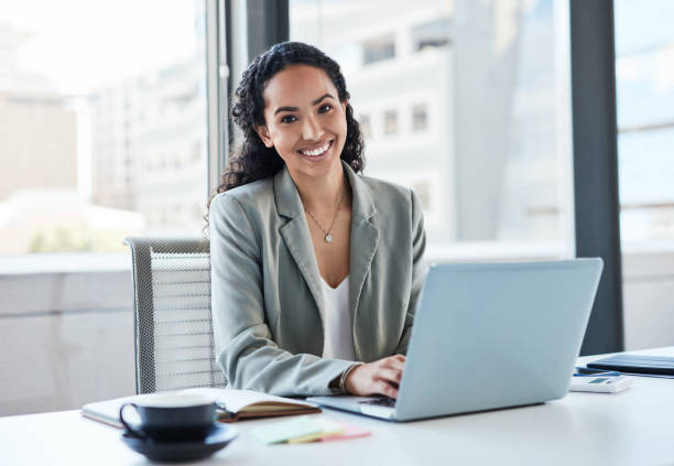 Portrait of a young businesswoman working on a laptop in an office stock photo