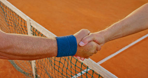 istock Shaking hands on clay court 1376150740