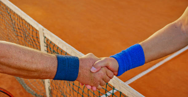 istock Shaking hands on clay court 1376151028