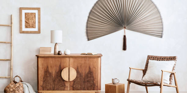 istock Interior design of neutral living room with stylish retro commode, mock up poster frame, cube, table lamp, decoration and elegant personal accessories in home decor. Template. Japandi concept.