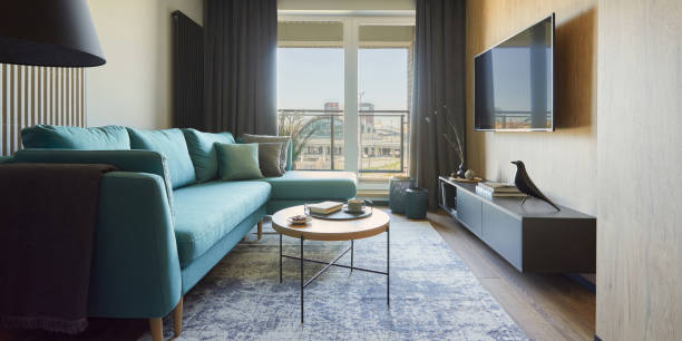 istock Creative composition of modern living room interior in small apartment. Eucalyptus sofa, coffee table and personal accessories. Windows with a big city view on. Template. 1376168291