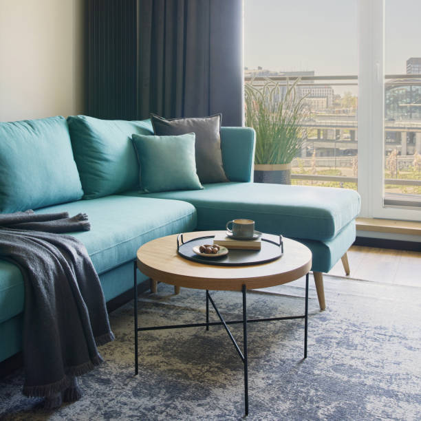istock Creative composition of modern living room interior in small apartment. Eucalyptus sofa, coffee table and personal accessories. Windows with a big city view on. Template. 1376168504