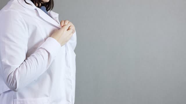 unrecognizable female doctor put on white uniform lab coat, preparing work