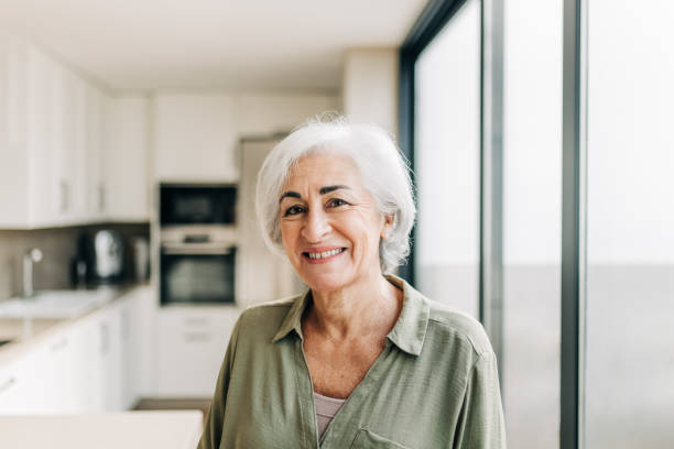 istock Happy elderly woman smiling cheerfully in her home 1376171659