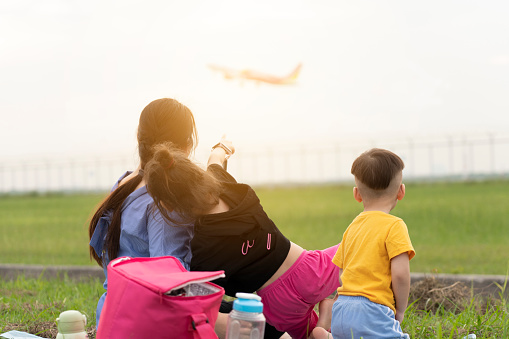Mother and child watching planes take off and land their children's dreams of becoming pilots. family having fun. Children dream to fly and become a pilot.