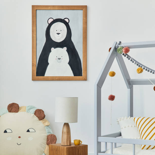 istock Stylish scandinavian child's room interior with mock up poster frame, creative bed, wooden cube, lamp, plush and wooden toys and hanging textile decorations. Grey wall, carpet on the floor. Template. 1376175755