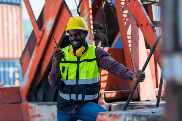 istock Foreman holding walkie- talkie for control working at Container cargo site. Handheld walkie talkie for outdoor 1376186026