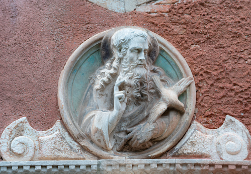 A beautiful sculpture of a Saint and dove above a doorway to the Chiesa di San Vidal.
