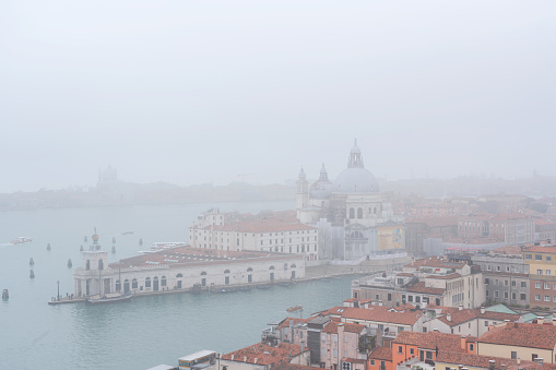 The gondolas on the river water overlooking Venice on a foggy day in Italy