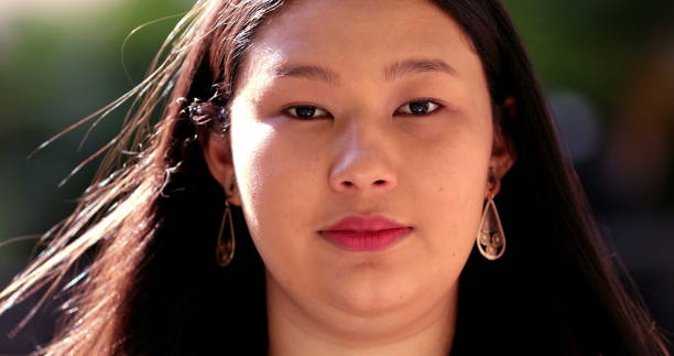 istock Asian young woman no expression portrait outside at park 1376196692