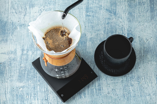 Professional barista brews coffee using chemex. Alternative ways to brew coffee. Coffee shop concept.