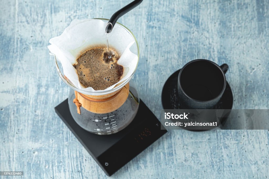 Professional barista brews coffee using chemex. Alternative ways to brew coffee. Coffee shop concept. Pouring Stock Photo