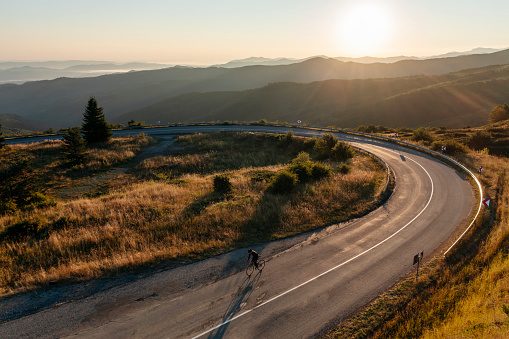 Mountain biker riding on a road on sunset.